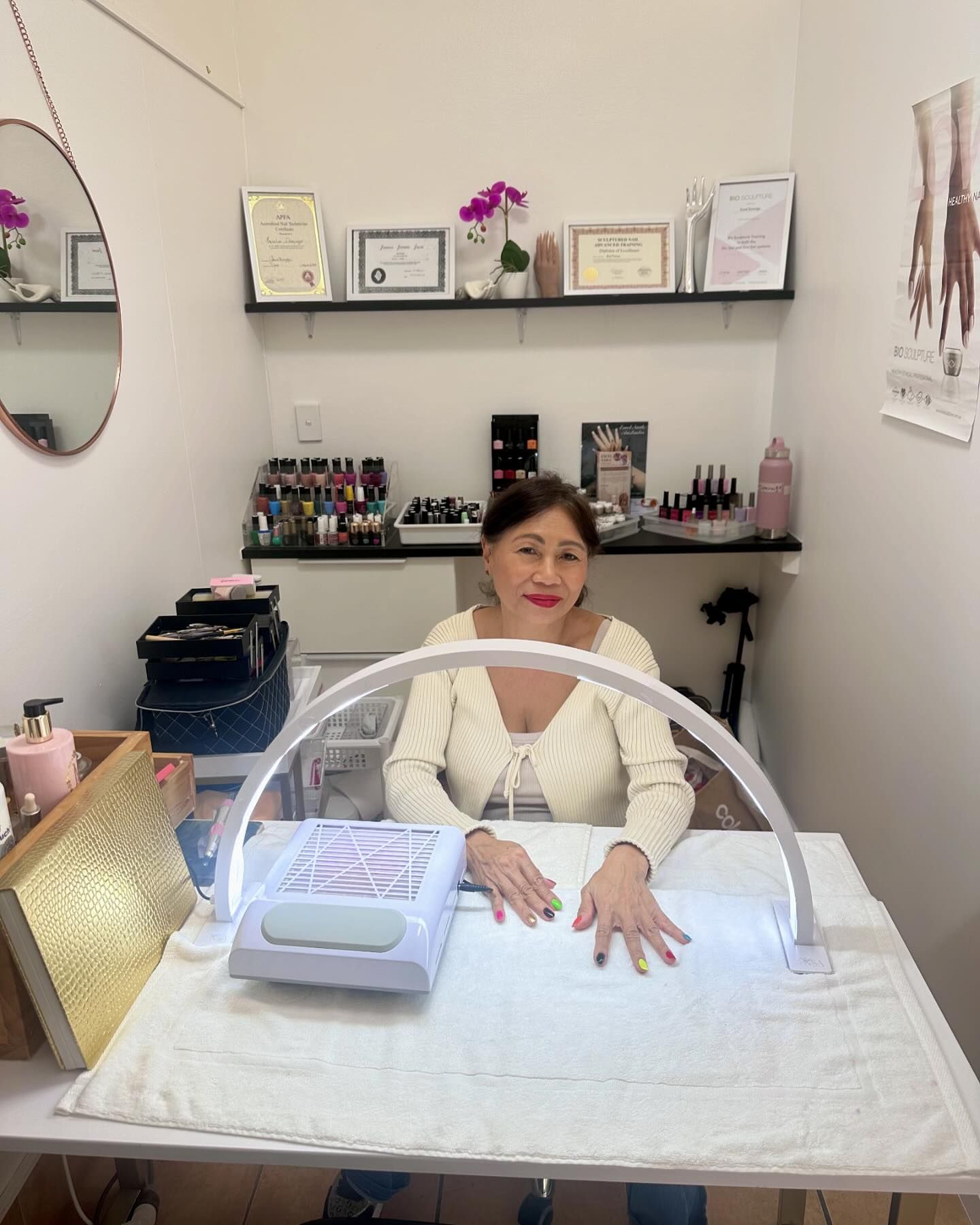 Female nail technician sitting at bench in beauty salon